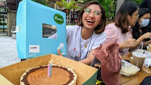 Manila, Philippines. A young woman from the Philippines, smiles while showing off a cake, taken during a gathering in Manila, to celebrate OpenStreetMap's 18th cakeday.