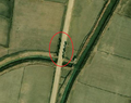 1/6 Piliers en pierre (barrier=tank_trap) le long de la route après un pont (imagerie satellite Maxar).