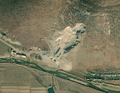 2/4 Zone minière (landuse=quarry) caractérisée par une plus faible rupture avec la végétation et un relief creusé repérable par les ombres. Elle est reconnaissable à sa couleur grise (imagerie satellite Maxar).