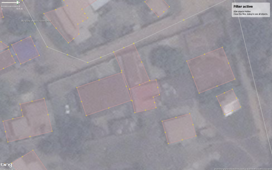 Typical buildings in West African city with a common mapping mistake, shared nodes with roads and other buildings.