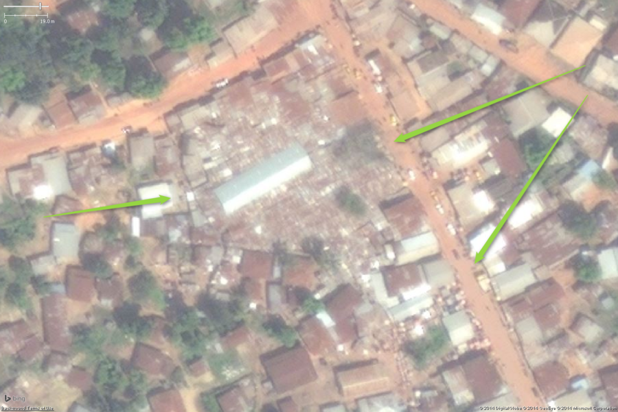 A likely marketplace in a large West African town. The key features are the small buildings tightly packed. In this example a rather large area is so densely packed with stalls the roofs appear to touch and overlap each other, covering almost an entire city block. The large building in the middle is probably a storage and distribution building. You can also see the stalls get slightly less densely packed in the areas and side streets around the main marketplace. The collection of small buildings should be tagged amenity=marketplace and fixme=confirm (unless you have first hand knowledge it is a marketplace).