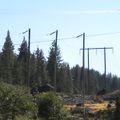 On older power lines with wooden towers, bends are often constructed this way, especially at high altitudes: each cable is carried on a separate quyed pole (in the background, a regular two-legged tower). Since the entire power line is mapped as a single way (with cables=3), I tagged the trio of poles as a single tower, not as three separate poles.