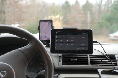 A car dashboard with a smartphone and tablet computer