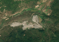 1/4 A mining area (landuse=quarry) characterised by a break with the nearby vegetation. It is recognisable by its grey colour (Maxar satellite imagery).
