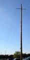 A guyed wooden pole rated at 115 kV / 60 Hz.