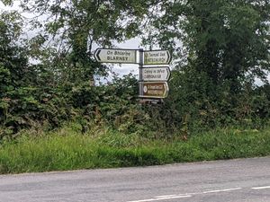 Bilingual signpost at Sluggera Cross, Co. Cork, Ireland..jpg. Destinations are in English and Irish (Gaeilge).