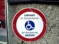 "Entrance for wheelchair users. In case of disability/blockade you'll get fined!" - The German word "Behinderung" stands for both hindrance/blockade and for disability.