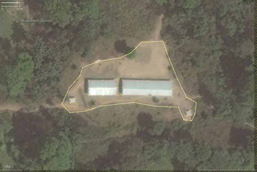 A typical rural school in West Africa. This zoomed in view shows the key features: 1 or 2 long buildings, 1 or 2 smaller toilet buildings, a large bare field. The overall school property should be tagged with amenity=school and the buildings with building=yes.