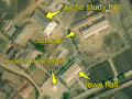 2/7 Another city centre regrouping a school (amenity=school), characterized by two long buildings (building=school) with a large courtyard in front (cf. Schools, a juche study hall (amenity=community_centre), with its specific shape, the immortality tower (historic=memorial and memorial=immortality_tower), with its shadow on the ground, and the city hall (amenity=townhall) (Maxar satellite imagery).