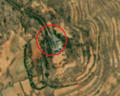 5/6 Communication tower (man_made=tower and tower:type=communication), with an antenna and a small building, on top of a plain (Maxar satellite imagery).